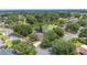 Birds eye view of a residential neighborhood with tree-lined streets and a tranquil pond at 1104 Kells Ct, Lakeland, FL 33813