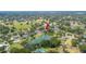 An aerial view showing a pond, surrounding houses, and lush greenery at 1104 Kells Ct, Lakeland, FL 33813