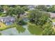 An aerial view showing houses with swimming pools next to a tranquil pond at 1104 Kells Ct, Lakeland, FL 33813