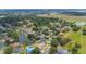 An aerial view shows homes surrounding a calm lake in a lush neighborhood with scenic views and manicured lawns at 1104 Kells Ct, Lakeland, FL 33813