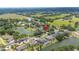An aerial view shows the location of a home among the other homes surrounding a calm lake in a lush neighborhood at 1104 Kells Ct, Lakeland, FL 33813