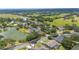 An aerial view shows homes surrounding a calm lake in a lush neighborhood with scenic views and manicured lawns at 1104 Kells Ct, Lakeland, FL 33813