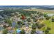 An aerial view shows the location of a home among the other homes surrounding a calm lake in a lush neighborhood at 1104 Kells Ct, Lakeland, FL 33813