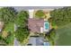 Aerial view of a well-maintained home with a private pool and mature trees near a pond at 1104 Kells Ct, Lakeland, FL 33813