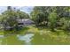 Picturesque backyard with a pond, a pool with a screen enclosure and plenty of mature trees for shade at 1104 Kells Ct, Lakeland, FL 33813