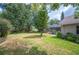 Expansive backyard with lush green grass and mature trees offering shade, including view of screened lanai at 1104 Kells Ct, Lakeland, FL 33813