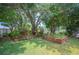Well-maintained backyard featuring lush landscaping, plants, trees and decorative garden beds at 1104 Kells Ct, Lakeland, FL 33813
