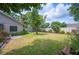 Secluded backyard featuring a spacious lawn, a mature tree and white fencing creating a private outdoor space at 1104 Kells Ct, Lakeland, FL 33813