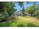 Expansive backyard with lush green grass, mature trees, landscaping, pool, and view of the back of the house at 1104 Kells Ct, Lakeland, FL 33813
