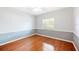 Empty bedroom with wood floors, wainscotting, ceiling fan and large window providing natural light at 1104 Kells Ct, Lakeland, FL 33813