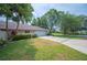 Front exterior view of the home showcasing the driveway, well-manicured lawn, and mature landscaping at 1104 Kells Ct, Lakeland, FL 33813