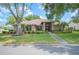 Charming single-story home featuring mature trees, lush landscaping, and a welcoming front entrance at 1104 Kells Ct, Lakeland, FL 33813