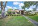 Charming single-story home featuring a well-manicured lawn, lush landscaping, and a welcoming entrance at 1104 Kells Ct, Lakeland, FL 33813