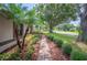 The side view of a cozy house featuring lush landscaping, palm trees and a stone walkway at 1104 Kells Ct, Lakeland, FL 33813