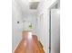 Bright hallway featuring hardwood floors, white walls, and access to other rooms within the home at 1104 Kells Ct, Lakeland, FL 33813