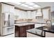 Kitchen with stainless steel refrigerator, dark countertops, light cabinets, and tile backsplash at 1104 Kells Ct, Lakeland, FL 33813