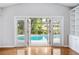 Living room view of pool through French doors and built-in shelving on the right at 1104 Kells Ct, Lakeland, FL 33813