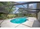 Screened pool featuring a spacious deck, with views of the community pond and mature trees at 1104 Kells Ct, Lakeland, FL 33813