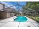 Outdoor pool in screened enclosure surrounded by lush landscaping and blue skies at 1104 Kells Ct, Lakeland, FL 33813
