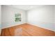 A well-lit room with wood floors, a window, and crisp white walls at 1104 Kells Ct, Lakeland, FL 33813