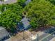 Aerial view of a cozy home with a screened in porch, nestled amongst lush trees and a fenced yard at 1720 Kendrick Ln, Lakeland, FL 33805