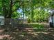 View of the backyard with mature trees and chain link fence at 1720 Kendrick Ln, Lakeland, FL 33805