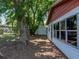 View of the backyard with mature trees, white vinyl siding, and storage shed at 1720 Kendrick Ln, Lakeland, FL 33805