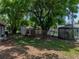 Large backyard with mature trees, chain link fence, storage sheds, and an AC unit at 1720 Kendrick Ln, Lakeland, FL 33805