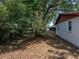 View of the backyard with mature trees and white vinyl siding at 1720 Kendrick Ln, Lakeland, FL 33805