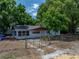 Exterior shot of home with mature trees, a fence, and clean landscaping at 1720 Kendrick Ln, Lakeland, FL 33805