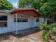 Front exterior view of home with red trim and mature landscaping at 1720 Kendrick Ln, Lakeland, FL 33805