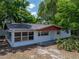 Charming home with red trim, a covered porch, and ample windows at 1720 Kendrick Ln, Lakeland, FL 33805