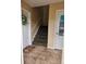 Tiled hallway with carpeted stairs, white door, and a decorative wreath at 1920 E Edgewood Dr # T6, Lakeland, FL 33803