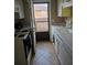 Kitchen features white cabinets, appliances, tile backsplash, and balcony access at 1920 E Edgewood Dr # T6, Lakeland, FL 33803