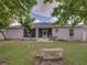 Back exterior of the home featuring a screened patio and lush backyard at 2033 Normandy Heights Dr, Winter Haven, FL 33880