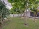Backyard featuring several trees, green grass, and a white vinyl fence at 2033 Normandy Heights Dr, Winter Haven, FL 33880
