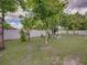 This backyard features a white fence and lush lawn dotted with trees and charming benches at 2033 Normandy Heights Dr, Winter Haven, FL 33880