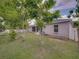 Spacious backyard with a screened-in porch, lush lawn, and beautiful mature trees at 2033 Normandy Heights Dr, Winter Haven, FL 33880