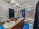 Bathroom features double vanity, neutral tile, and tub with shower at 2033 Normandy Heights Dr, Winter Haven, FL 33880