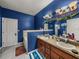 Bathroom featuring a dual sink vanity, bathtub, and blue textured walls at 2033 Normandy Heights Dr, Winter Haven, FL 33880