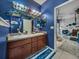 Bathroom featuring a dual sink vanity, blue textured walls, and natural lighting at 2033 Normandy Heights Dr, Winter Haven, FL 33880