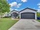View of the home's charming exterior with an attached two car garage and a long private driveway at 2033 Normandy Heights Dr, Winter Haven, FL 33880
