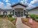 Home's front porch features tasteful landscaping, elegant columns, and inviting double door entry at 2033 Normandy Heights Dr, Winter Haven, FL 33880