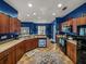 Wide angle of kitchen featuring wood cabinetry and black appliances, plus blue dishwasher at 2033 Normandy Heights Dr, Winter Haven, FL 33880