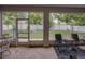 Enclosed patio with tiled floor featuring backyard views of manicured trees and a white fence at 2033 Normandy Heights Dr, Winter Haven, FL 33880