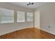 Sunlit bedroom featuring hardwood floors, three windows, and modern lighting at 2814 Coventry Ave, Lakeland, FL 33803