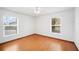 Bright bedroom featuring two windows and hardwood floors at 3226 Cherry Hill S Cir, Lakeland, FL 33810