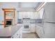 The kitchen features white cabinets and appliances and wood-style floors at 3226 Cherry Hill S Cir, Lakeland, FL 33810
