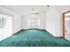 Bright living room with green carpet, ceiling fan, bay windows, and sliding glass doors at 3226 Cherry Hill S Cir, Lakeland, FL 33810