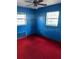 Bedroom featuring blue painted walls and red carpeting with two windows at 411 Keat Ave, Auburndale, FL 33823